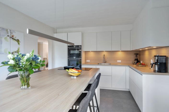 Keuken in Scandinavische stijl met mat-witte kasten en lichte houtlook