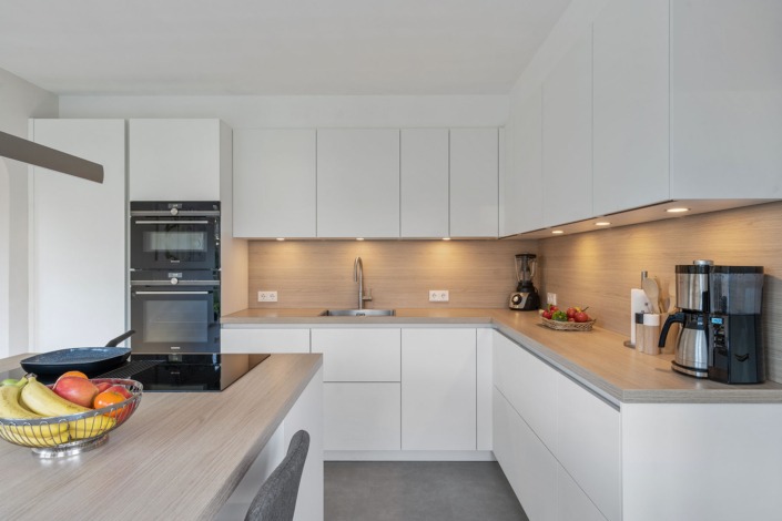 Keuken in Scandinavische stijl met mat-witte kasten en lichte houtlook